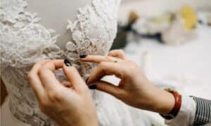 addetta al lavaggio abiti da sposa controlla minuziosamente le rifiniture finito il trattamento
