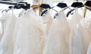 diversi abiti da sposa bianchi tutti perfettamente lavati sulle stampelle